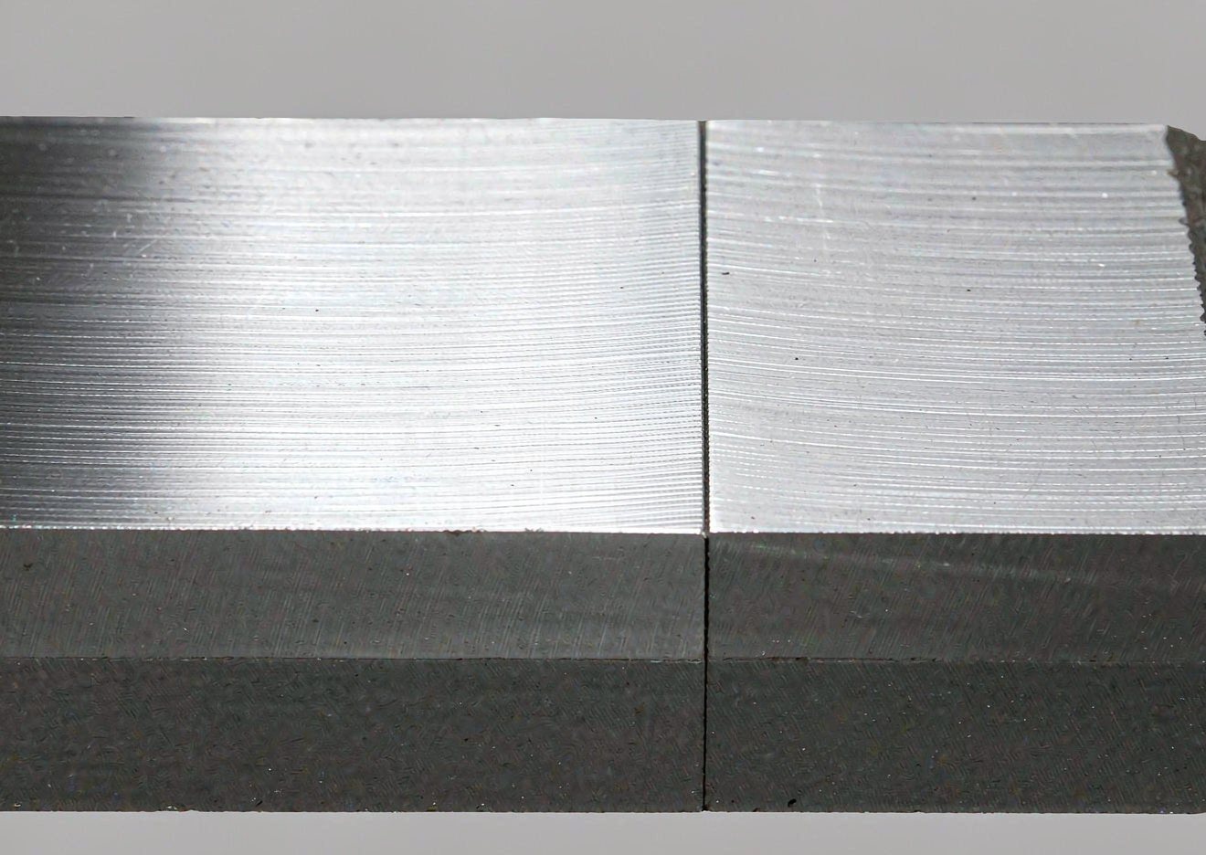 Macro close-up of a clad plate cut edge showing the stainless layer bonded to the carbon steel base